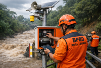 Ilustrasi: Petugas BPBD Kota Cimahi yang melakukan pengecekan rutin pada salah satu perangkat Early Warning System (EWS) pemantau muka air sungai. Di tengah ancaman cuaca ekstrem yang diprediksi mencapai puncaknya pada Maret mendatang, kesiapan infrastruktur peringatan dini dan koordinasi personel menjadi kunci utama dalam menjaga 15 kelurahan rawan bencana di Cimahi agar tetap siaga menghadapi potensi banjir bandang dan longsor. Ilustrasi: Kabar Pajajaran
