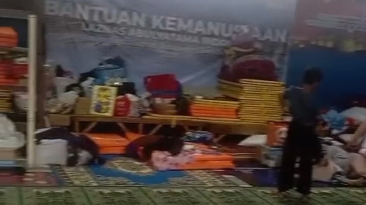 Sejumlah warga dan anak-anak pengungsi beraktivitas di dalam GOR Desa Pasirlangu yang kini menjadi pusat pengungsian utama sementara aula desa dialihfungsikan sebagai pusat penyimpanan logistik bantuan. Foto: Istimewa