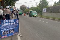 Petugas Satlantas Polresta Bandung saat memberikan edukasi dan memeriksa kelengkapan surat-surat kendaraan pengendara dalam Operasi Keselamatan Lodaya 2026 di wilayah Soreang, Senin (9/2/2026). Operasi ini memprioritaskan penindakan ETLE bagi pelanggar lalu lintas. Foto: AW/Kabar Pajajaran