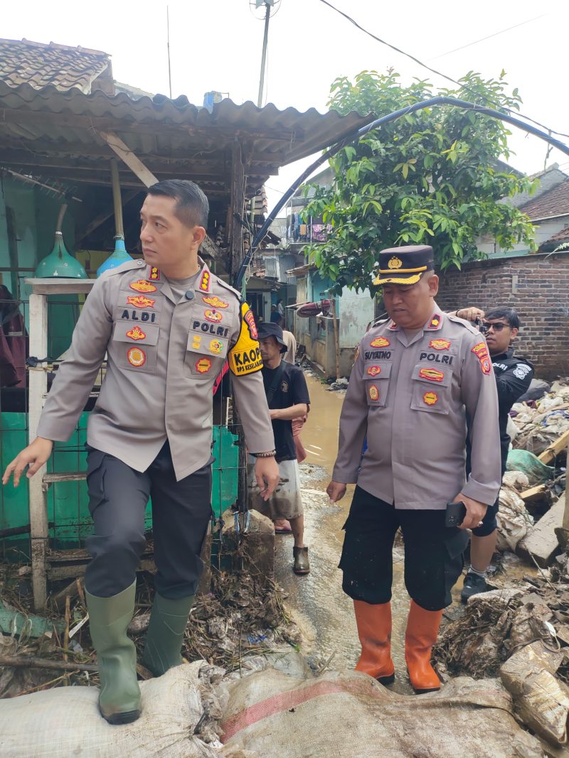 Kapolresta Bandung Kombes Pol Aldi Subartono turun langsung membantu membersihkan lumpur di rumah warga terdampak banjir akibat jebolnya tanggul Sungai Cisunggalah di Desa Bojong, Kecamatan Majalaya, Kabupaten Bandung, Kamis (12/2/2026). Foto: Istimewa