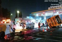 Petugas kepolisian dan tim medis saat berupaya mengevakuasi korban dari dalam badan bus yang terguling di depan Gerbang Tol Waru Utama, Sidoarjo, yang sempat menyebabkan kepadatan arus lalu lintas. Foto: Jasa Marga Surgem