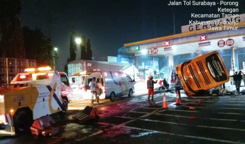 Petugas kepolisian dan tim medis saat berupaya mengevakuasi korban dari dalam badan bus yang terguling di depan Gerbang Tol Waru Utama, Sidoarjo, yang sempat menyebabkan kepadatan arus lalu lintas. Foto: Jasa Marga Surgem