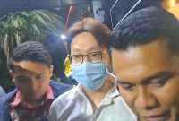 Richard Lee terlihat digiring petugas kepolisian menuju arah ruang tahanan Polda Metro Jaya usai menjalani pemeriksaan di Gedung Direktorat Reserse Kriminal Khusus (Ditreskrimsus), Jumat (06/3/2026) malam.(Kompas.comDisya Shaliha)
