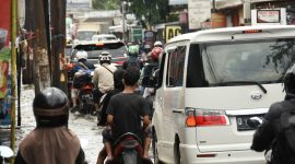 Kendaran bermotor tampak menerobos lokasi jalan yang terendam banjir di jalan Derwati Kelurahan Derwati Kecamatan Rancasari Kota Bandung, selasa (4/3/2025).(KOMPAS.COM/AGIE PERMADI)