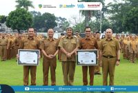 Pemerintah Kota Tasikmalaya menyerahkan piagam predikat Menuju Wilayah Bebas dari Korupsi (WBK) kepada Dinas Kependudukan dan Pencatatan Sipil Kota Tasikmalaya dalam Apel Pagi Gabungan di Lapangan Balekota Tasikmalaya, Senin (23/2/2026). (Dok Humas Kominfo)