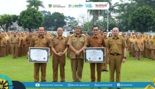 Pemerintah Kota Tasikmalaya menyerahkan piagam predikat Menuju Wilayah Bebas dari Korupsi (WBK) kepada Dinas Kependudukan dan Pencatatan Sipil Kota Tasikmalaya dalam Apel Pagi Gabungan di Lapangan Balekota Tasikmalaya, Senin (23/2/2026). (Dok Humas Kominfo)