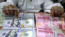 Pegawai menunjukan mata uang rupiah dan dolar Amerika Serikat di Dolar Asia Money Changer, Jakarta, Senin (18/7/2022). Bisnis/Himawan L Nugraha