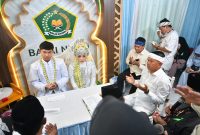 Gubernur Jawa Barat Dedi Mulyadi menjadi saksi akad nikah pasangan penyandang disabilitas tuna rungu di KUA Bale Endah, Kabupaten Bandung, Jumat (1/5/2026). Prosesi berlangsung khidmat dengan bantuan juru bahasa isyarat. Foto: Humas Jabar