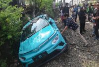 Warga mengamati taksi listrik Green SM yang rusak pascakecelakaan dengan KRL Commuter Line dan KA Argo Bromo Anggrek di Bekasi Timur, Bekasi, Jawa Barat, Selasa (28/4/2026). (ANTARA FOTO/Fakhri Hermansyah)