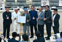 Gubernur Jawa Barat Dedi Mulyadi bersama pimpinan DPRD Jawa Barat menunjukkan dokumen persetujuan Ranperda Pertanggungjawaban Pelaksanaan APBD Tahun Anggaran 2025 yang resmi disetujui menjadi Peraturan Daerah dalam rapat paripurna di Gedung DPRD Jawa Barat, Selasa (14/7/2026). (Foto: Humas Jabar)