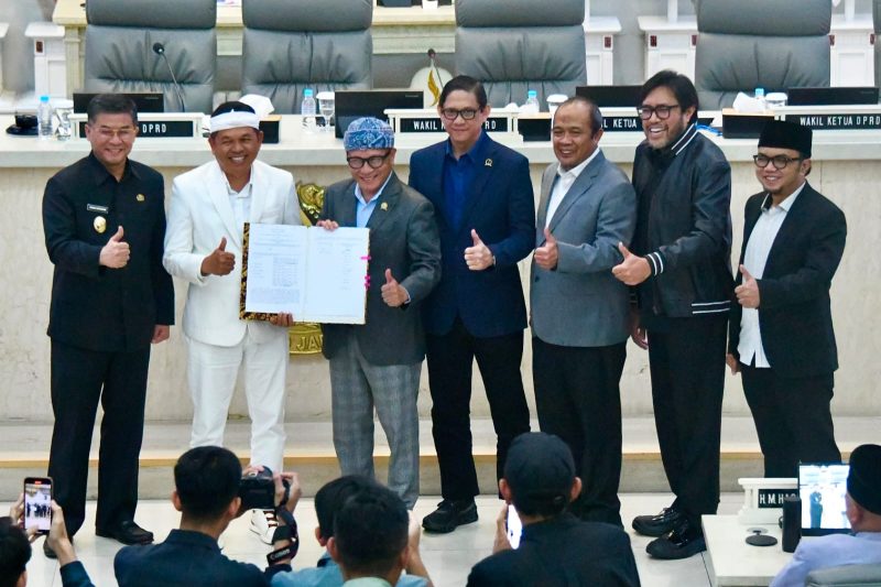 Gubernur Jawa Barat Dedi Mulyadi bersama pimpinan DPRD Jawa Barat menunjukkan dokumen persetujuan Ranperda Pertanggungjawaban Pelaksanaan APBD Tahun Anggaran 2025 yang resmi disetujui menjadi Peraturan Daerah dalam rapat paripurna di Gedung DPRD Jawa Barat, Selasa (14/7/2026). (Foto: Humas Jabar)