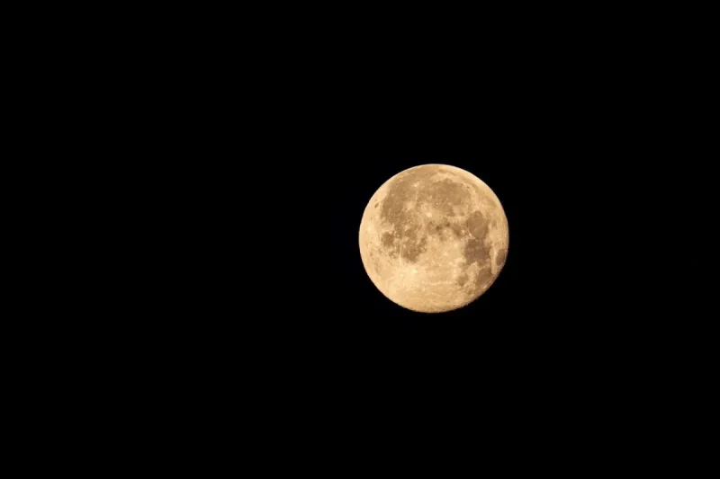 Ilustrasi: Bulan purnama berwarna kekuningan bersinar terang di langit malam yang gelap gulita. · Foto: Francesco Ungaro / Pexels