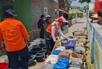 Warga mengantre bantuan air bersih yang datang ke Desa Jatilaksana, Kecamatan Pangkalan, Karawang, Jawa Barat

