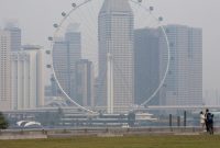Foto: Singapore Flyer dan gedung-gedung komersial diselimuti kabut asap di kawasan Marina Bay, Singapura. (REUTERS/Ore Huiying)
